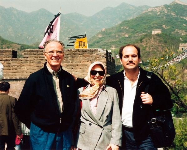 Três visitantes posam diante da Grande Muralha da China